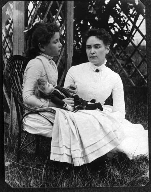 A picture showing anne sullivan teaching helen keller in a garden
